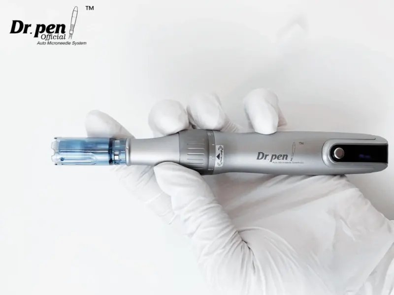 手袋をはめた手でマイクロニードル皮膚ペン Dr. Pen M8S を保持します